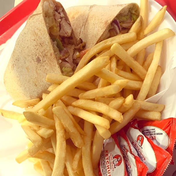 Grilled chicken wrap with fries and ketchup packets from Chick 'n Chop on the Grill.